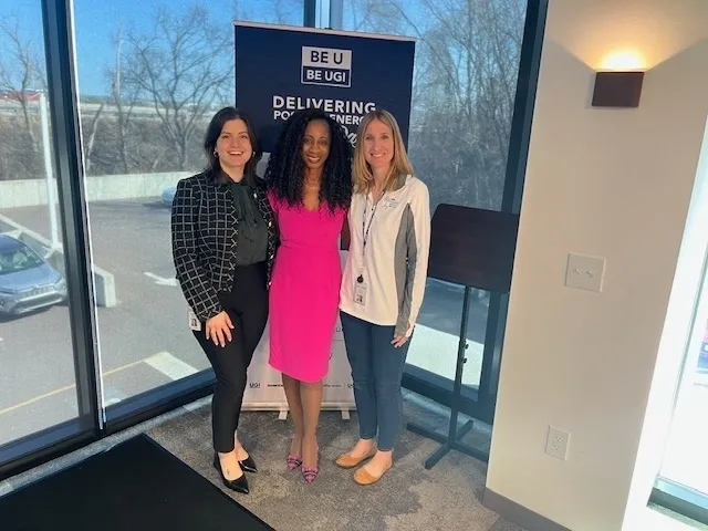 Three women posing in an office setting.