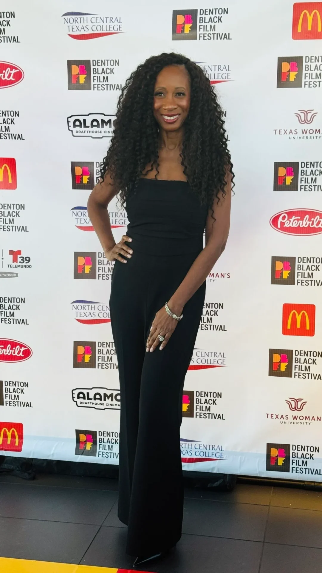 Woman in black outfit at film festival.